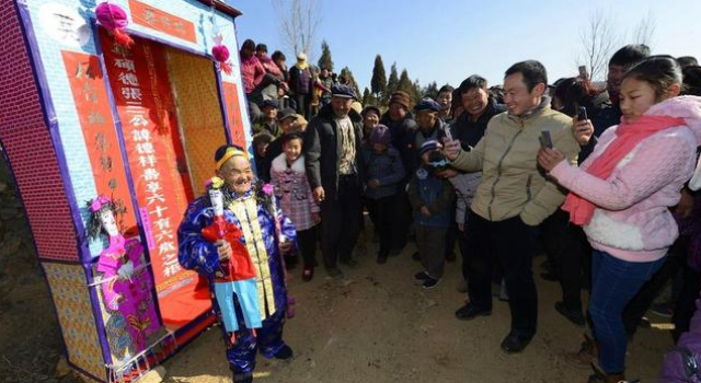 山东6旬老农自办“活人出殡” 穿寿衣钻坟墓逗乐村民