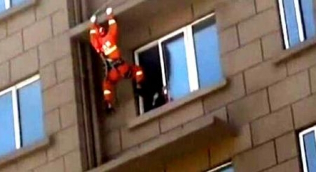 机智!徐州女子坐6楼窗台欲跳楼 消防员一脚将其踹回屋