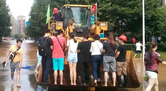 霸气!积水严重武汉市民乘铲车上班 1次10元供不应求