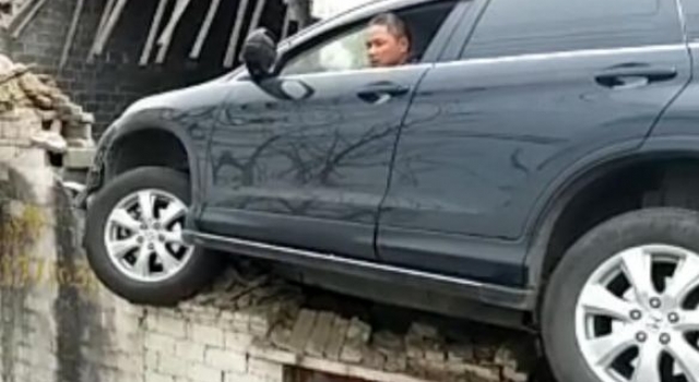 如此车祸太离奇：SUV为避让三轮车飞上路边3米高屋顶