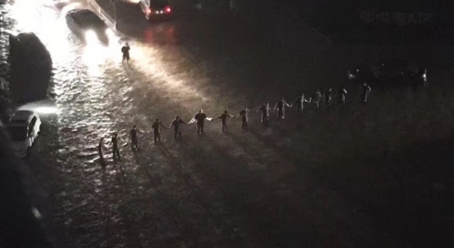 北京强降雨被淹 武警官兵暴雨中筑人墙