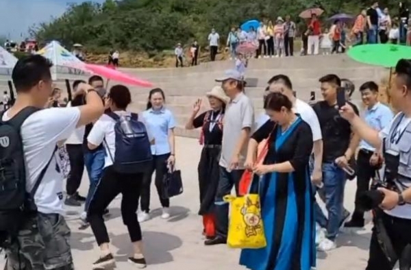 冯巩外出游玩，人气爆棚遭师奶围堵合影，娇妻颜值太高同框似父女